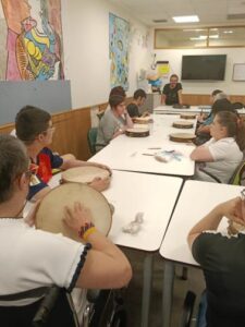 Personas usuarias del CAI ASPAYM practican con panderetas durante el taller impartido por Ramsés Ilesies.