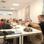 Ramsés Ilesies explica distintos toques de pandereta durante el taller con las personas usuarias del CAI ASPAYM.