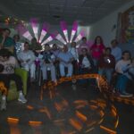 Participantes del CAI ASPAYM posan en grupo durante un taller de pintura con luz.