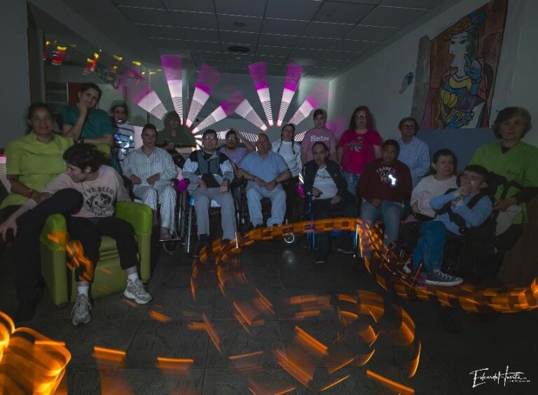 Participantes del CAI ASPAYM posan en grupo durante un taller de pintura con luz.